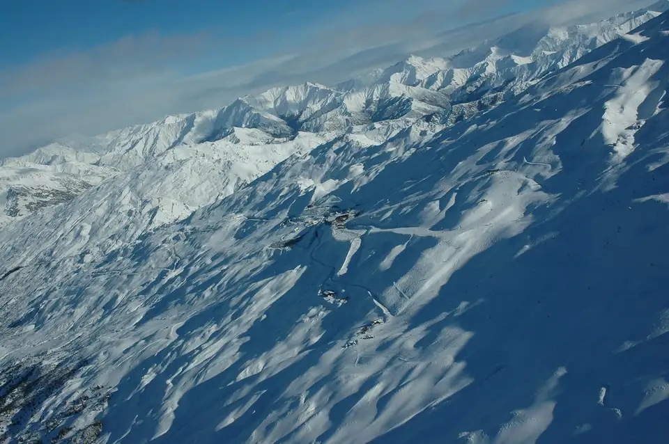 Snow-covered slopes and groomed runs at Coronet Peak