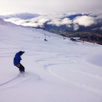 Lone snowboarder enjoying fresh turns at Coronet Peak this morning