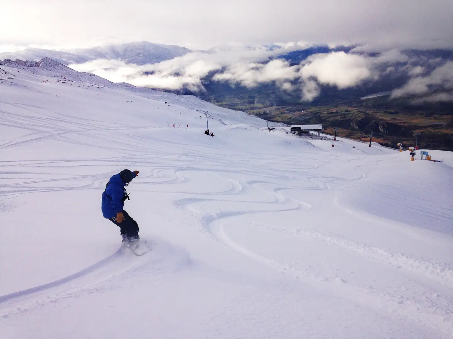Lone snowboarder enjoying fresh turns at Coronet Peak this morning