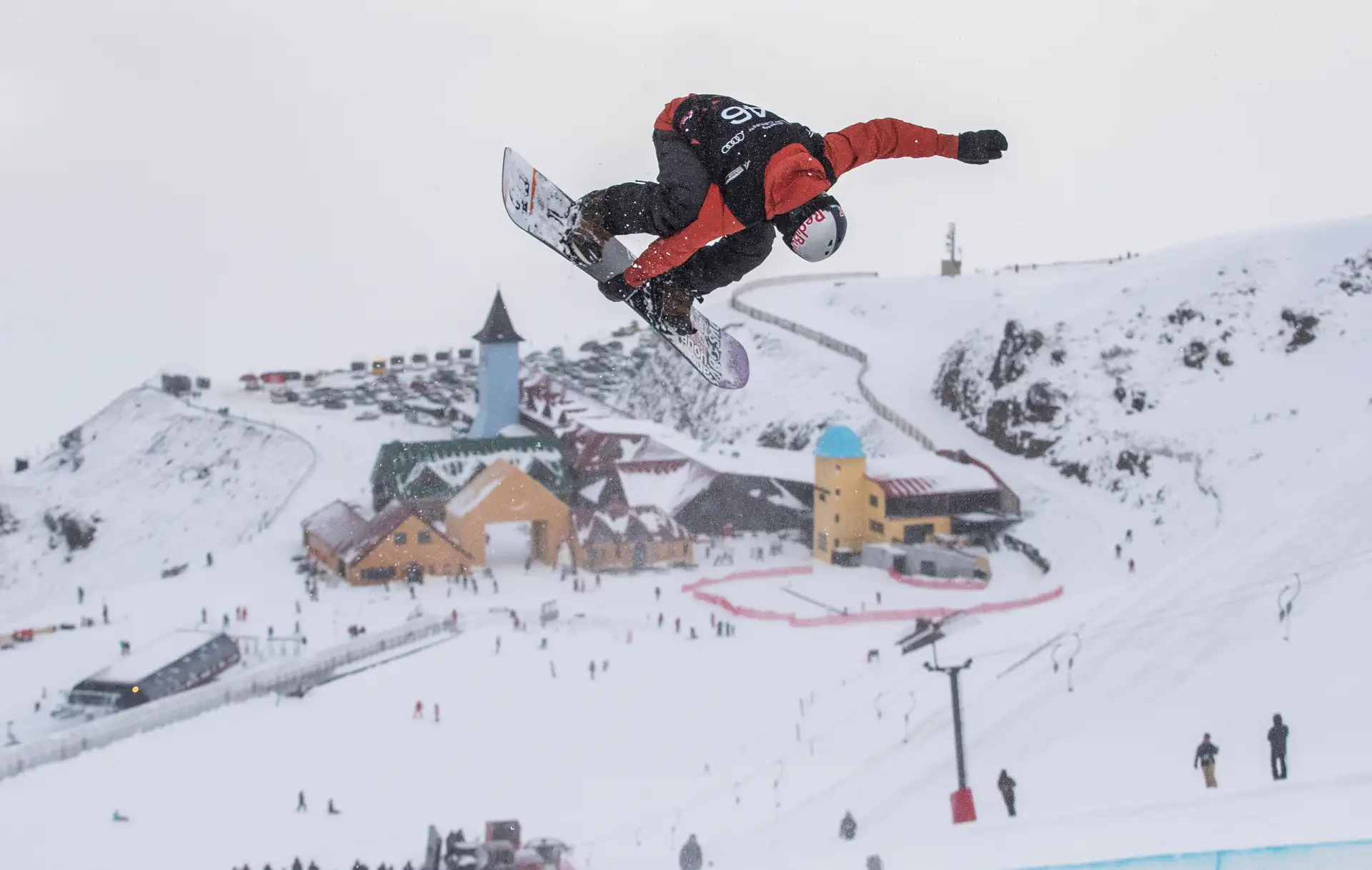 Snowboarder performing an aerial trick above a halfpipe