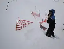 Liftie Hannah McKie shovelling out the fences after the snow at Coronet Peak