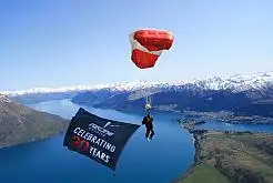 An NZONE instructor flying the birthday flag high above Queenstown