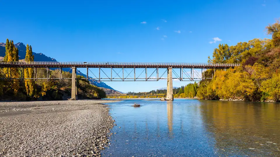 The Shotover River running blue-green through a rocky gorge below tussock hillsides