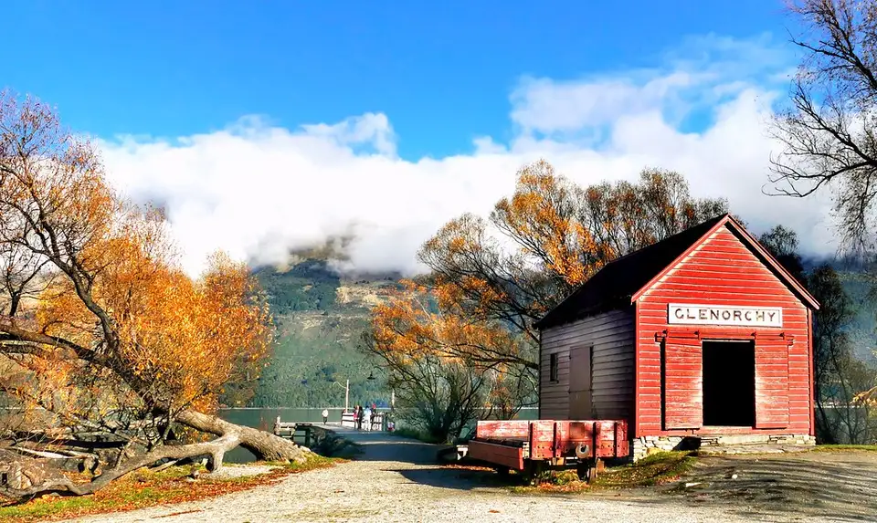 The red Glenorchy steamship depot shed on the lakefront with mountains behind