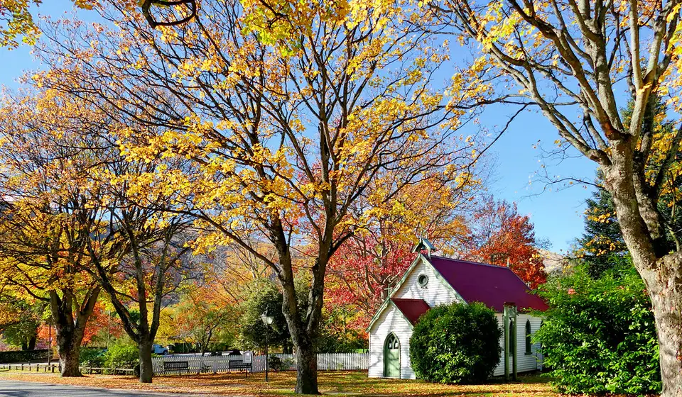 St Paul's church in Arrowtown behind autumn trees in full colour