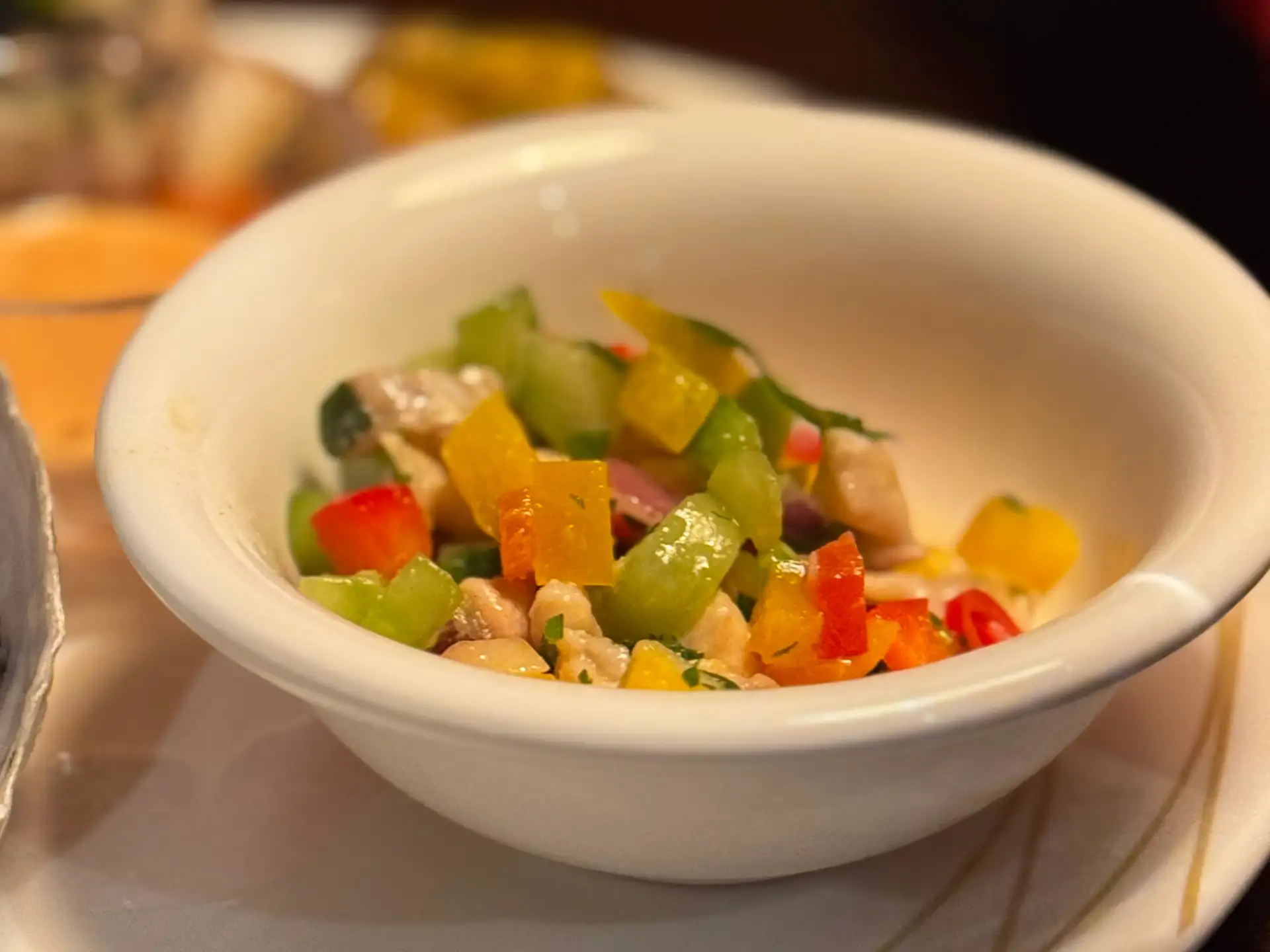A bowl of ika mata ceviche with diced fish, cucumber and red and yellow peppers at Prospects.