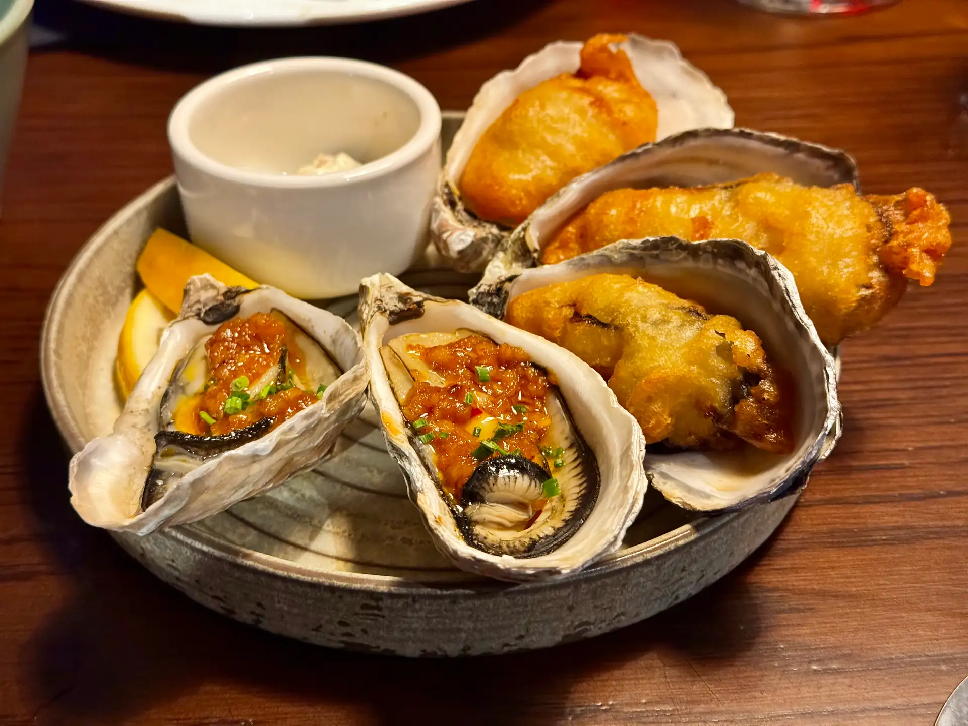 Grilled oysters with chilli garlic sauce and beer-battered oysters with a pot of tartare sauce on a stoneware plate at Prospects.